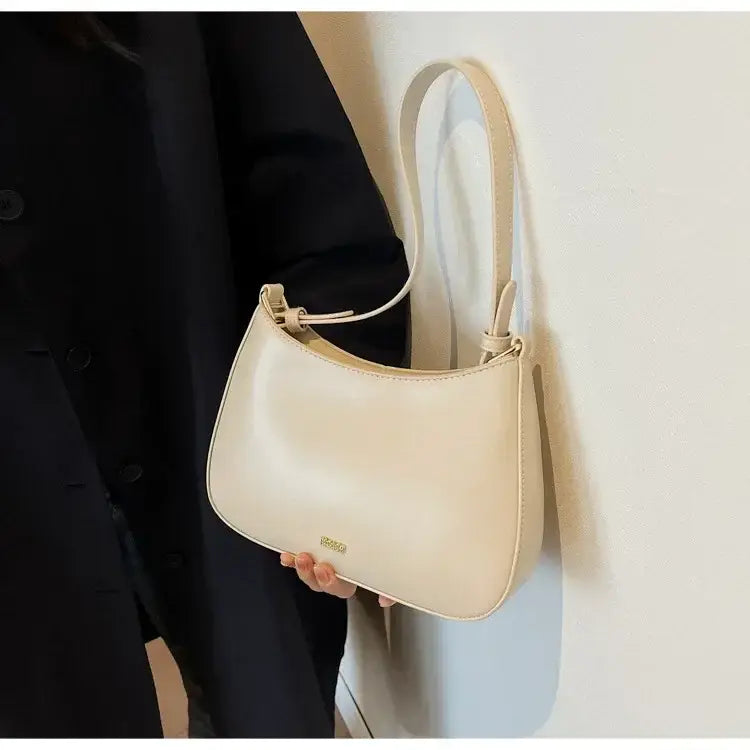 Cream-colored shoulder bag crossbody with curved top for a stylish luxury look.