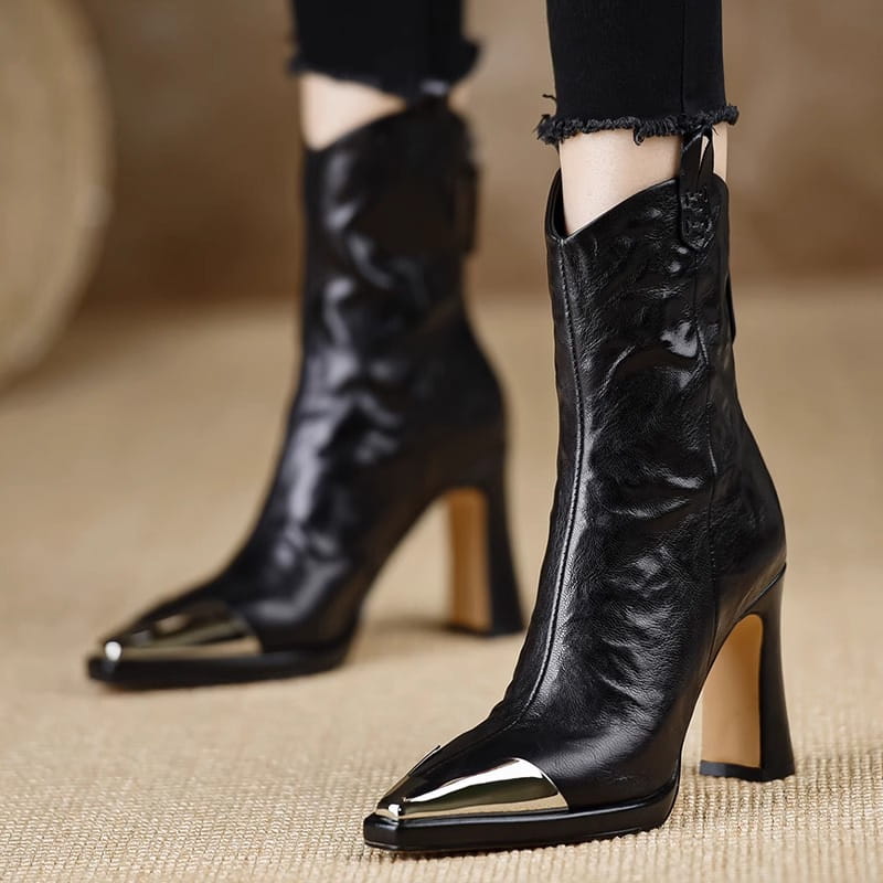 Black leather ankle boots with metallic toe caps for stylish retro mid-calf vibes.