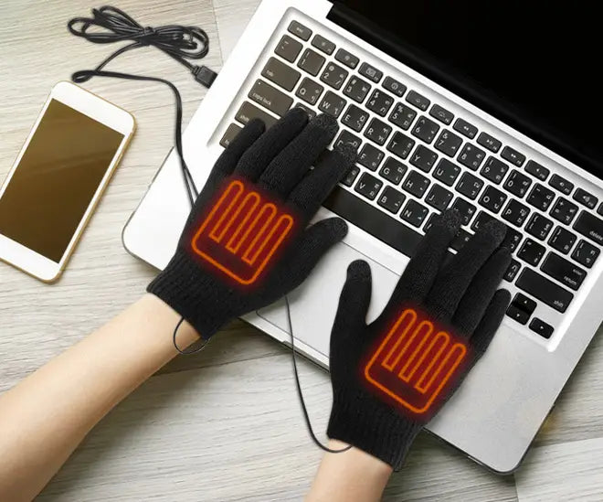 USB-powered heated electric gloves resting on a laptop keyboard for cozy comfort.