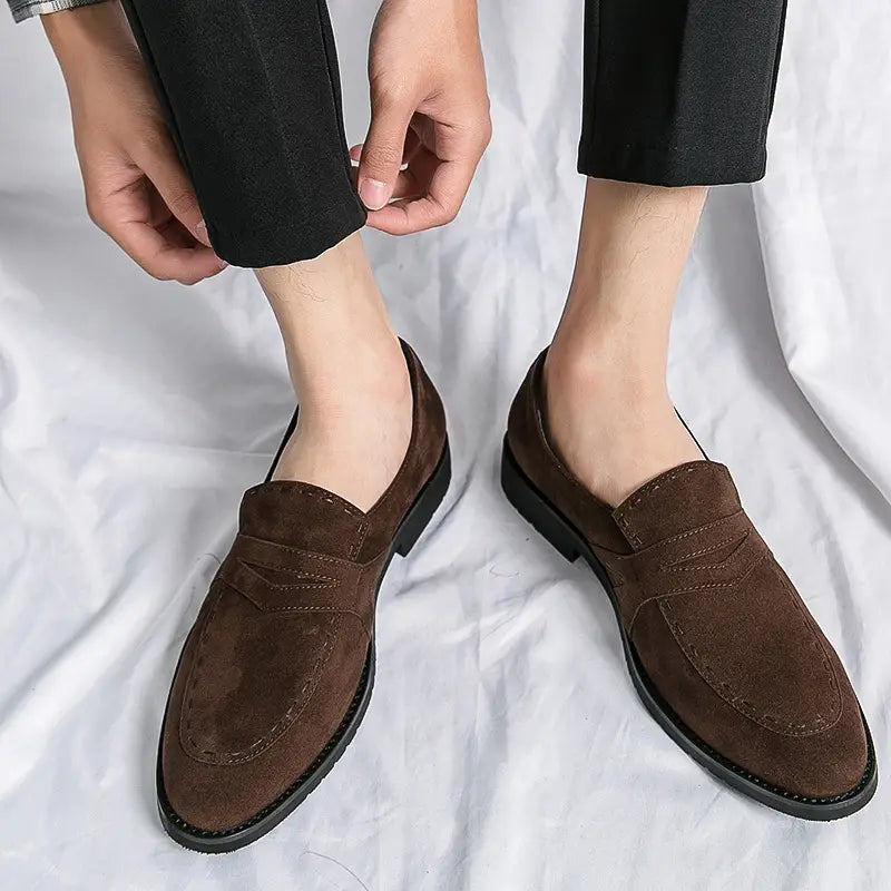 Brown suede penny loafers with classic stitching for everyday pointed toe casual style.