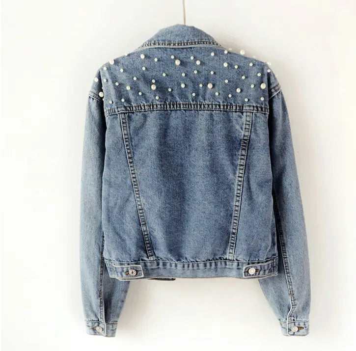 Light blue womens western denim jacket with pearl embellishments and loose sleeves.