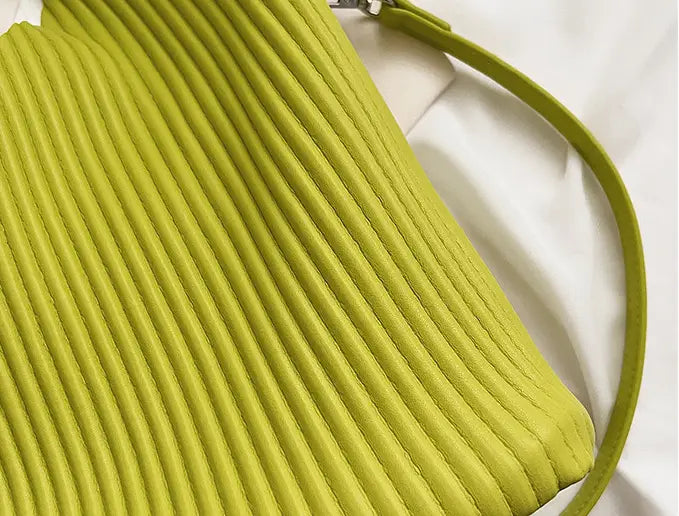 Lime-green ribbed handbag with strap, a stylish textured messenger bag for women’s niche fashionable style.