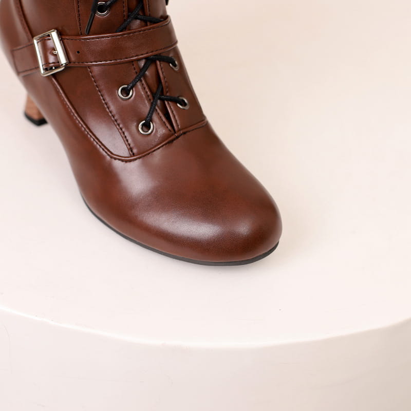 Brown leather mid heel lace-up ankle boot with laces and buckle strap.