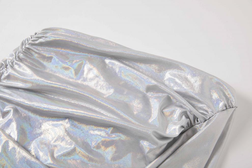 Crinkled metallic silver foil showcasing sexy asymmetrical design of cocktail dress.