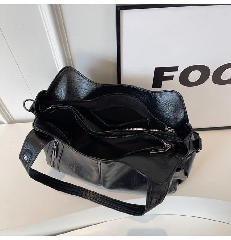 Sac messager de voyage à bandoulière multizip pour femmes en cuir noir avec des compartiments à fermeture éclair chic.