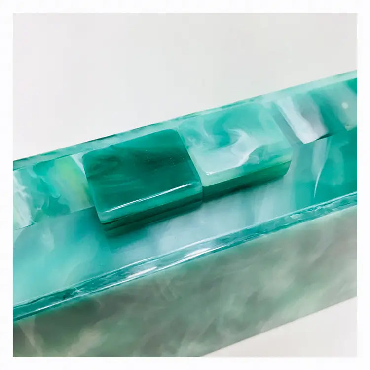 Translucent turquoise glass block in a stylish Emerald Green Marbled Acrylic Box Evening Handbag Luxury.