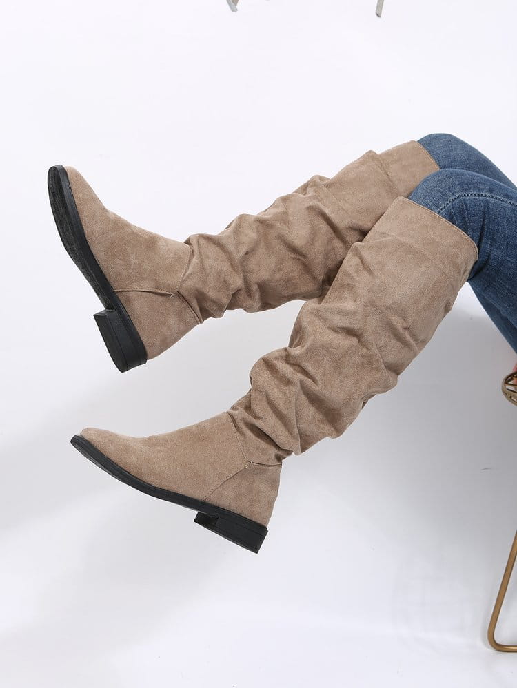 Slouchy tan faux suede knee-high boots with a flat heel for stylish ladies.