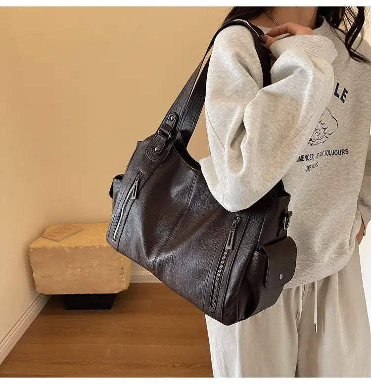 Sac hobo en cuir noir avec compartiments à fermeture éclair pour un messager de voyage élégant à bandoulière multi zip pour femmes.