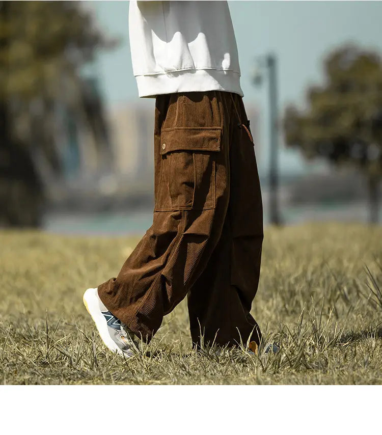 Brown corduroy cargo pants with pockets styled with white sneakers for casual comfort.