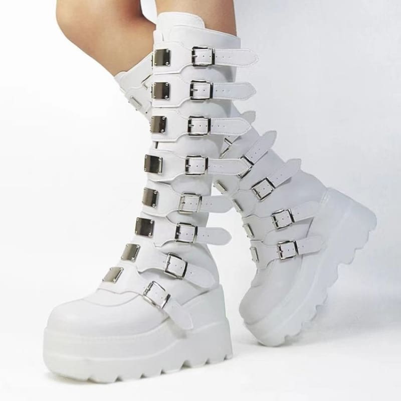 White knee-high platform boots with multiple buckle straps.