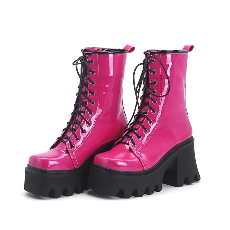 Hot pink patent boots with black laces, chunky soles, and thick heels for a bold look.