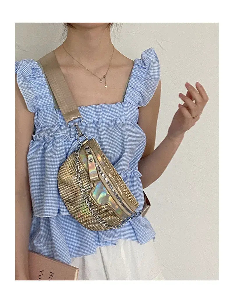 Gold metallic fanny pack with holographic accents styled on blue gingham, perfect rhinestone luxury.