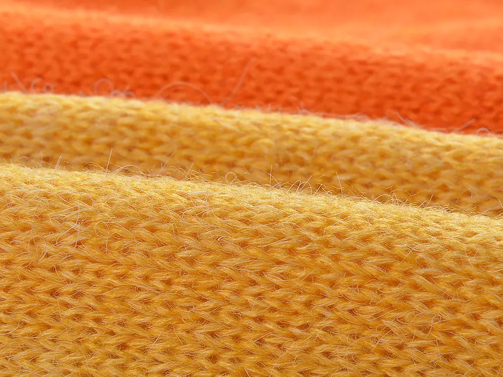 Layers of knitted fabric in orange and yellow for Ladies Rainbow Cloud Short Sweater.