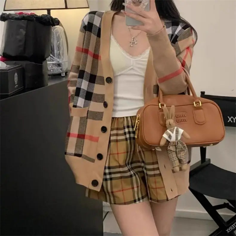 Stylische Strickjacke mit Burberry-Muster für Damen mit passenden karierten Shorts und Handtasche.