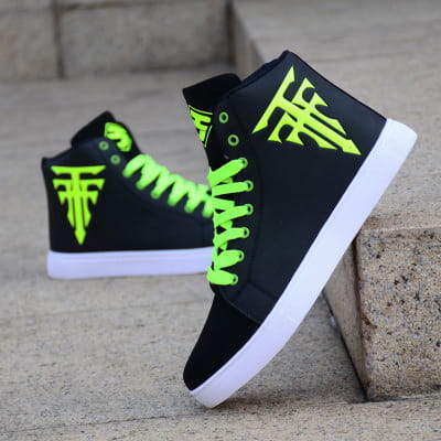 Des chaussures de planche montantes noires avec des lacets vert fluo pour une tenue décontractée élégante pour les hommes.