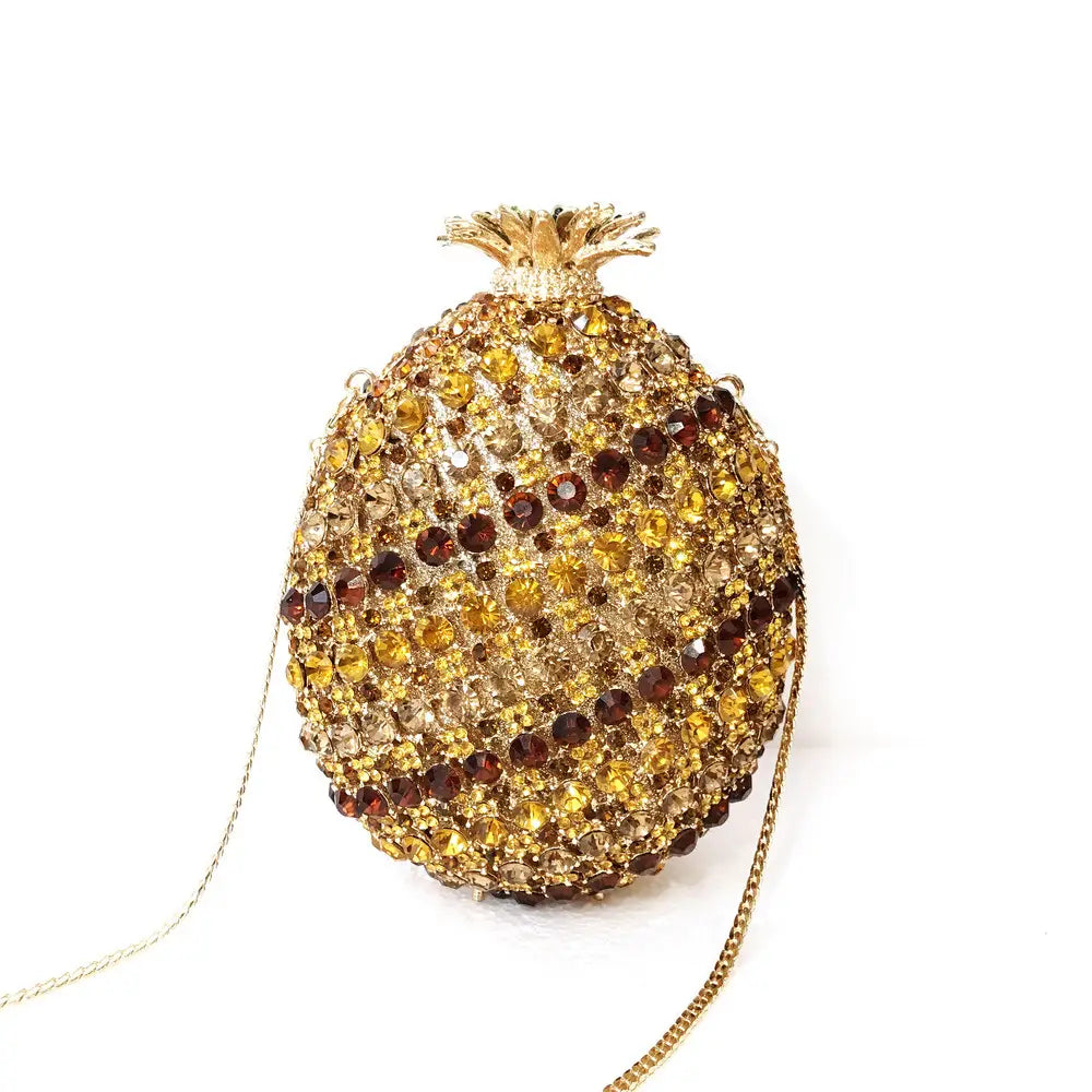 Glittering pineapple shaped crystal clutch purse with golden and burgundy crystals.