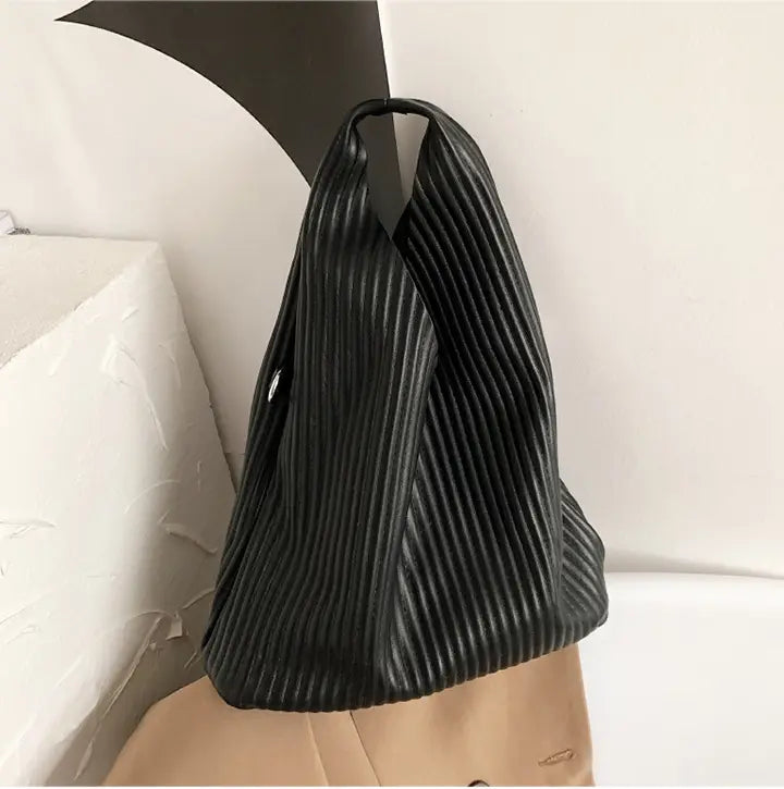 Black pleated triangle handbag with ribbing for a textured messenger bag vibe.