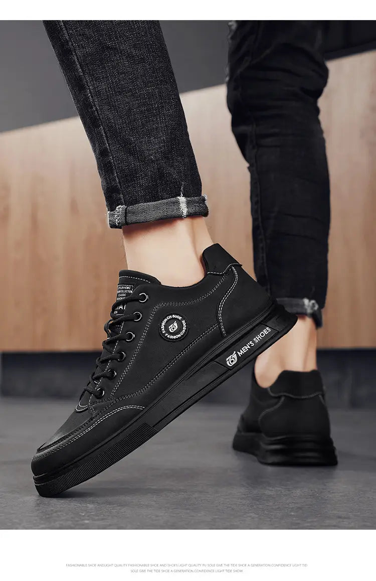 Black lace-up sneakers paired with rolled-up dark denim, perfect for men’s British style soft soled casual shoes.