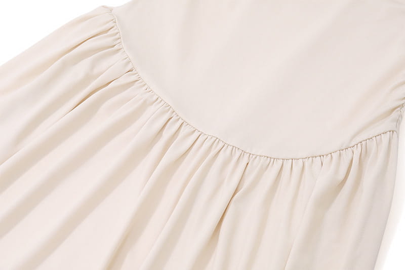 Cream-colored fabric with gathered pleats on a sexy slim fit pleated strapless dress.