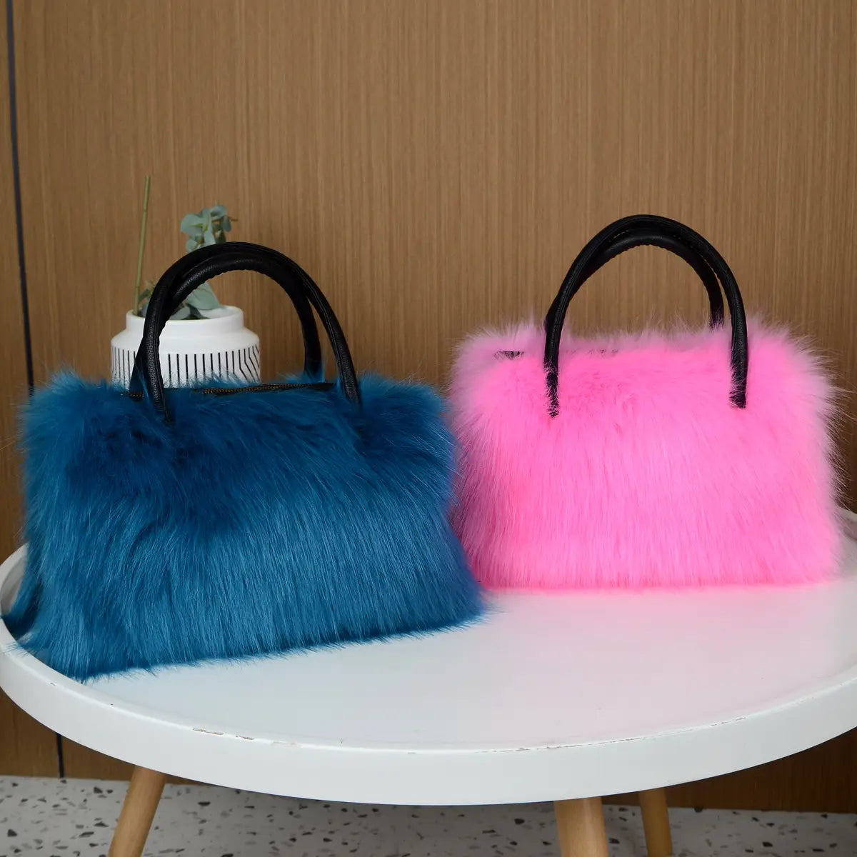 Two faux fur fluffy Boston handbags in blue and pink for cool winter vibes.