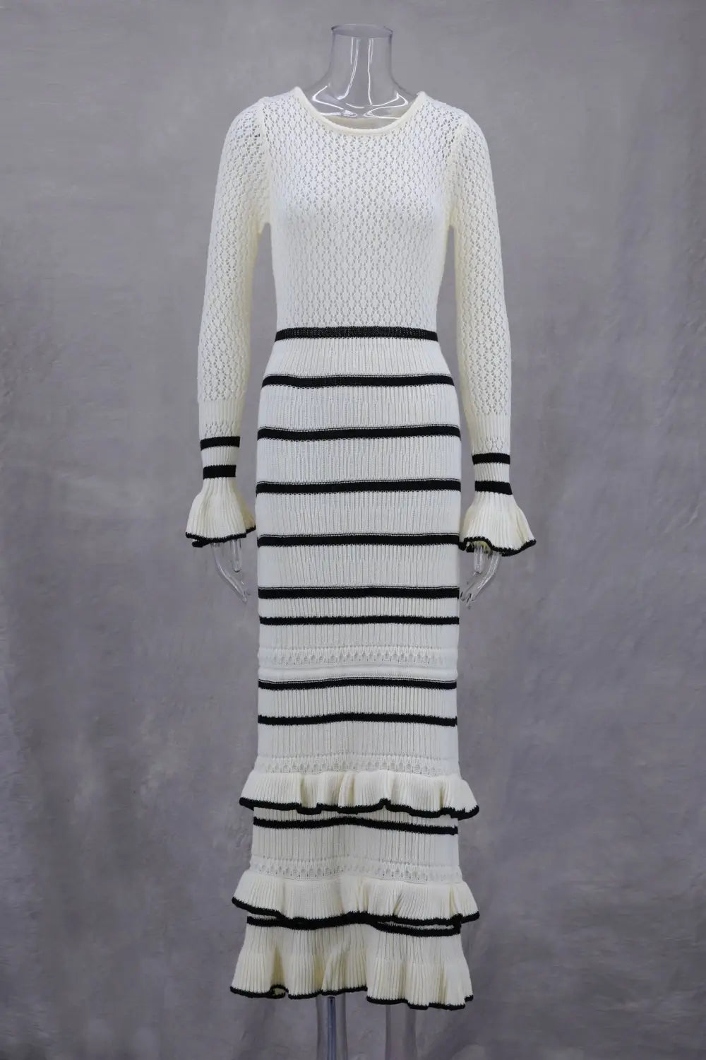 Stylish ladies knitted dress with black stripes and ruffled tiers for a trendy look.