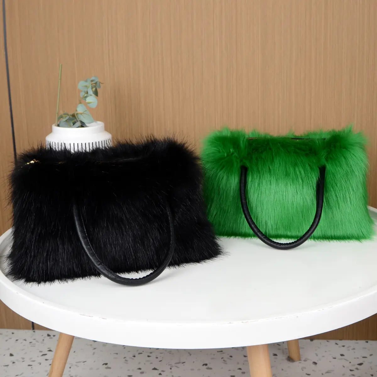 Two faux fur fluffy handbags, one black and one bright green, perfect for winter vibes.