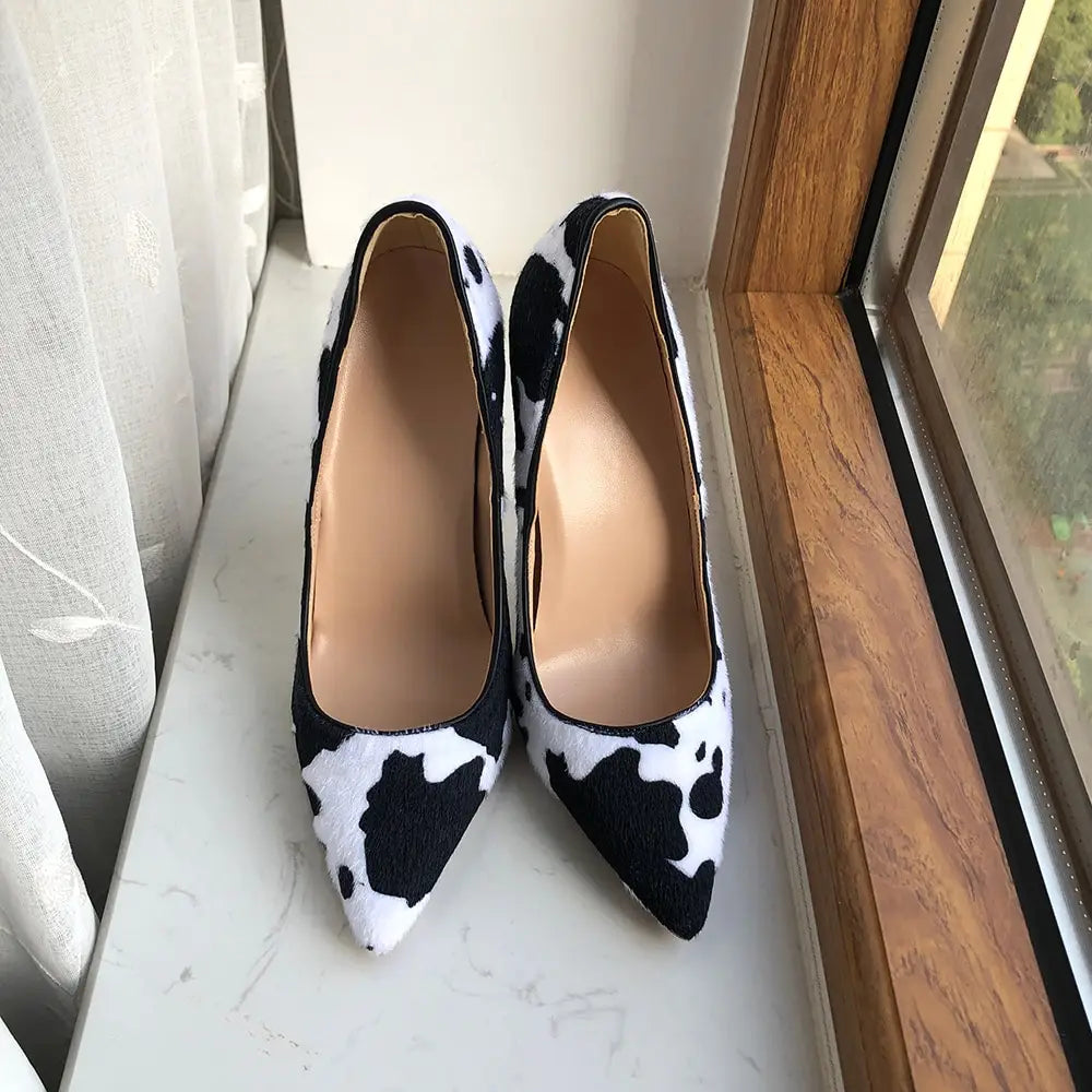 Pointed-toe high heels in a trendy black and white cow print hairy design.