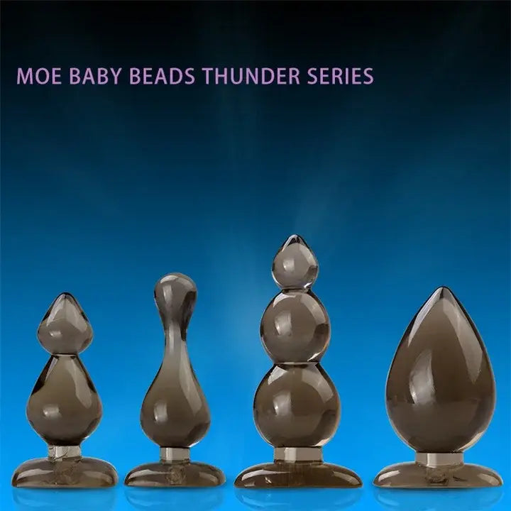 Four Smoky Brown Teardrop Silicone Waterproof Butt Plugs in different sizes for pleasure.