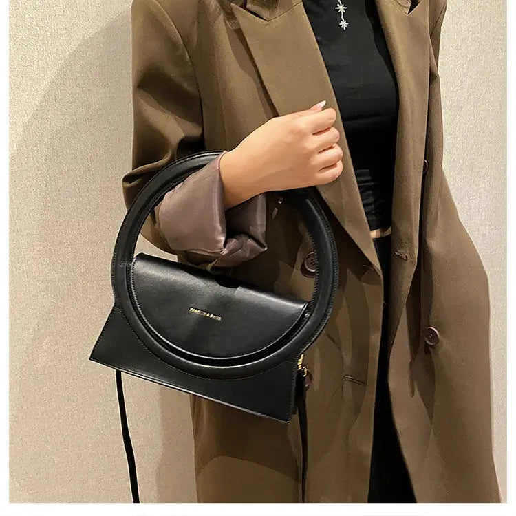 Sleek black leather handbag versatile retro design with curved top handle perfect for stylish days