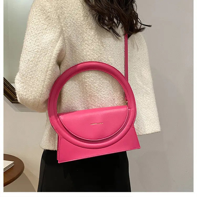 Hot pink geometric handbag versatile for shoulder and crossbody styles.