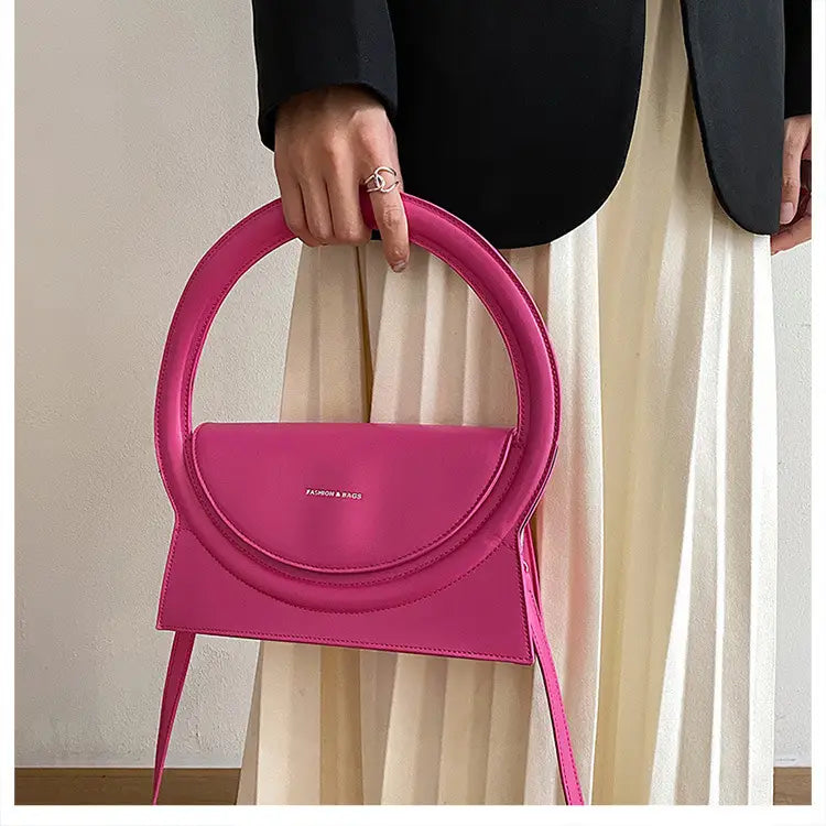 Hot pink half-moon handbag with circular handle, perfect designer handbag versatile crossbody bag.