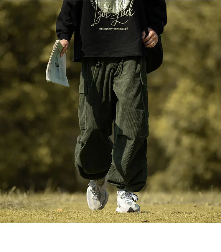 Olive green corduroy cargo pants with pockets paired with white sneakers for casual style.