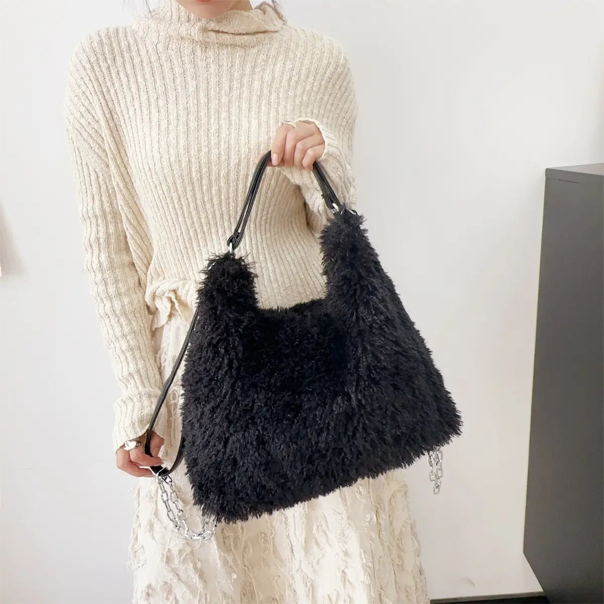 Black fluffy faux fur handbag with handles, perfect plush large capacity for stylish outings.