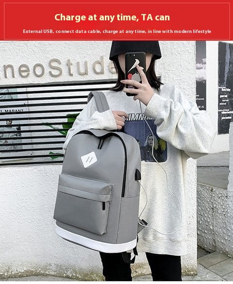 Gray backpack with pockets and white trim for large capacity USB computer travel.