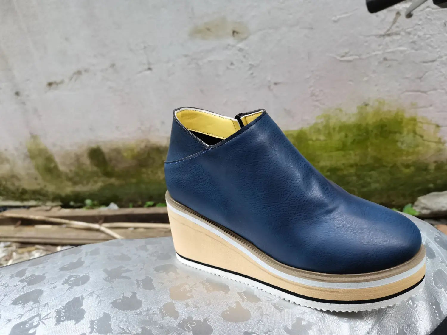 Navy blue leather surface ankle boots with zipper mid heel and white platform sole.