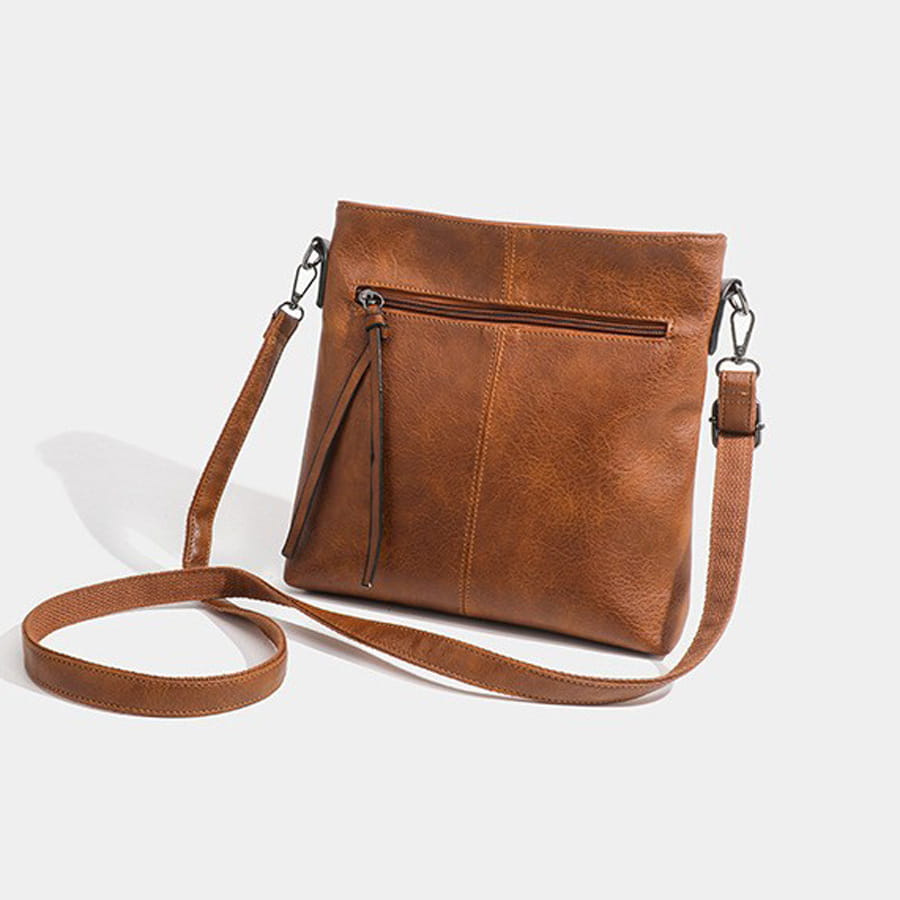 Brown leather crossbody bag with zippers, a stylish high-end textured artificial leather design.