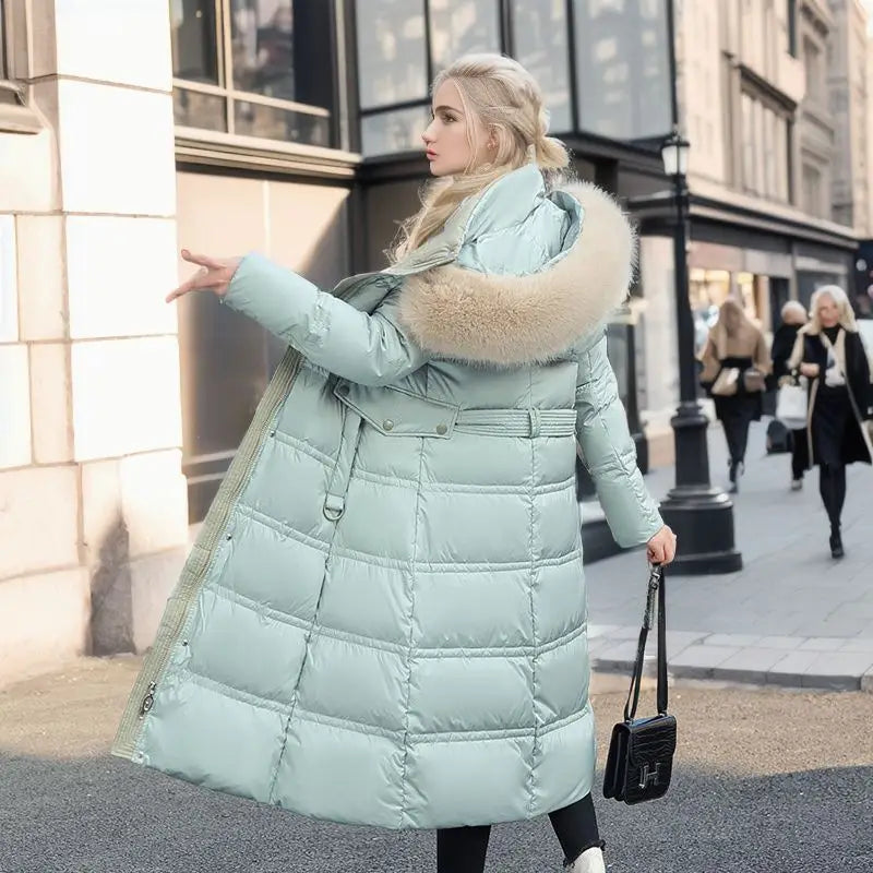 Mint green ladies long padded coat with luxurious fur-trimmed hood for stylish winter warmth.