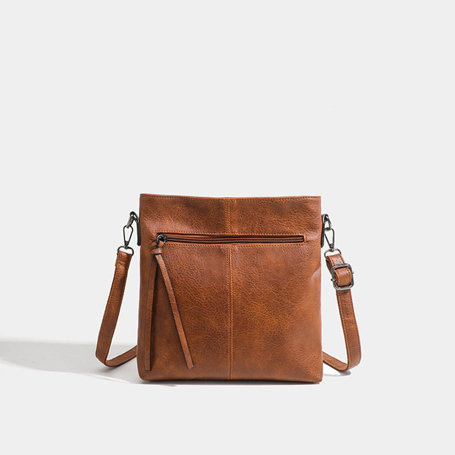 Brown leather crossbody bag with zipper and adjustable strap in high-end textured artificial leather.