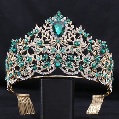 Ornate tiara featuring emerald-colored gemstones and diamonds in an intricate gold-toned setting.