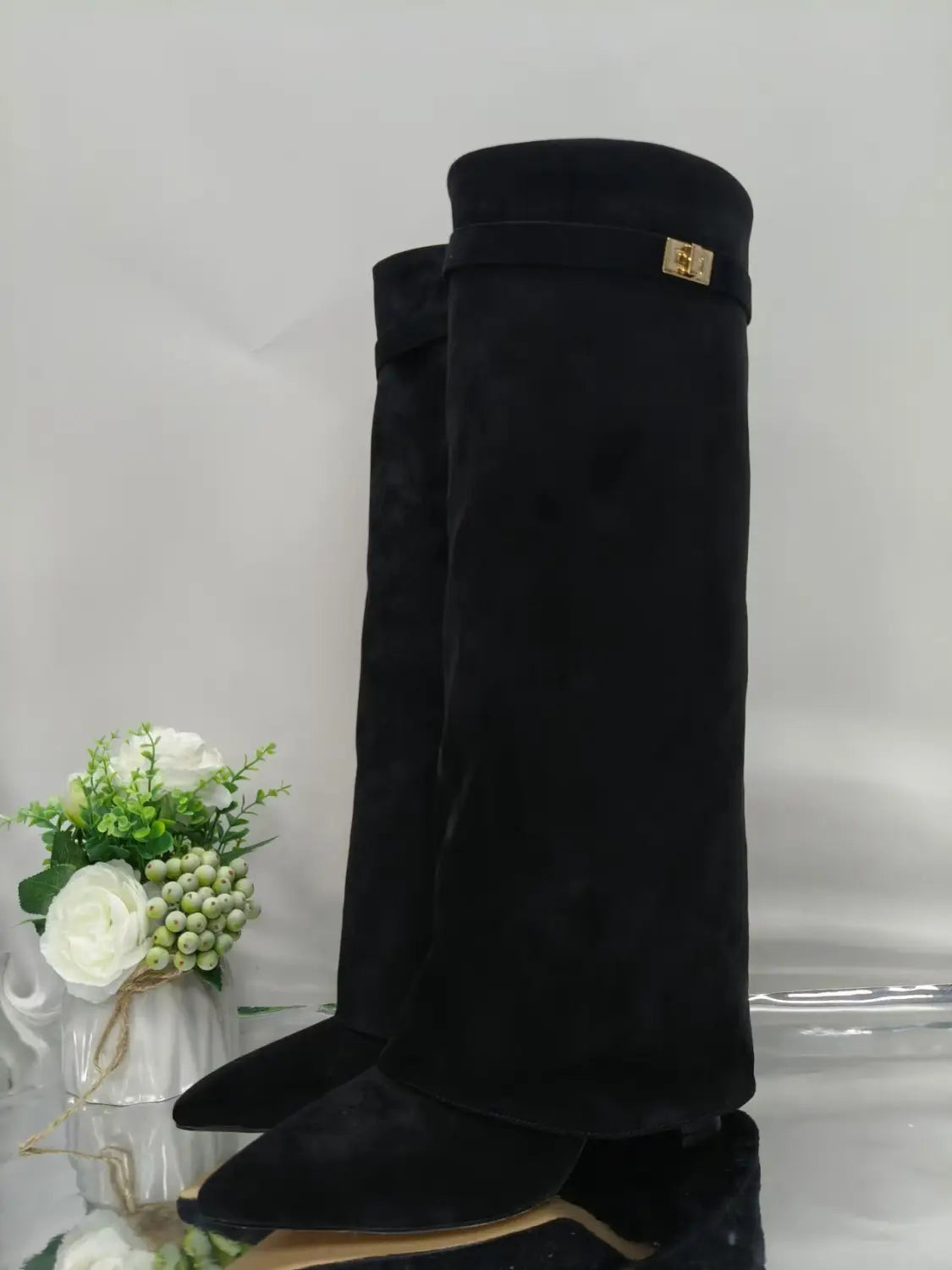 Grandes bottes en daim noir pour femmes, style Gucci, à bout pointu et à boucle métallique au niveau du genou, avec des accents dorés.