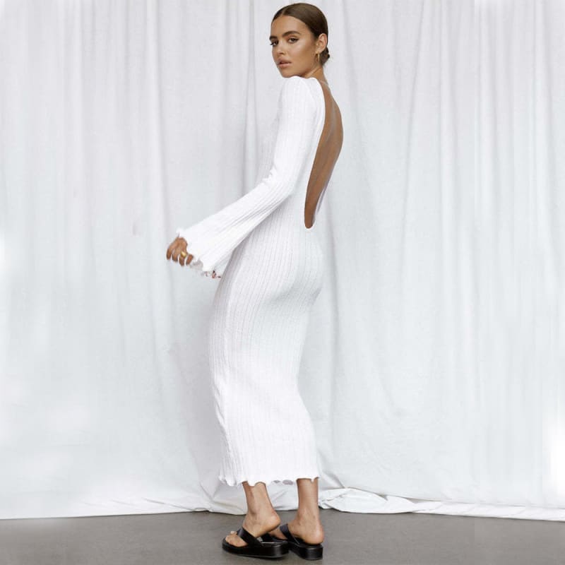 Long-sleeved white backless dress with a fitted silhouette and ankle-length hem.