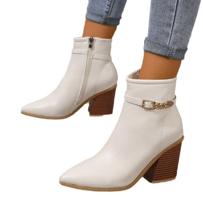 White ankle boots with chunky wooden heels and decorative gold chain details.