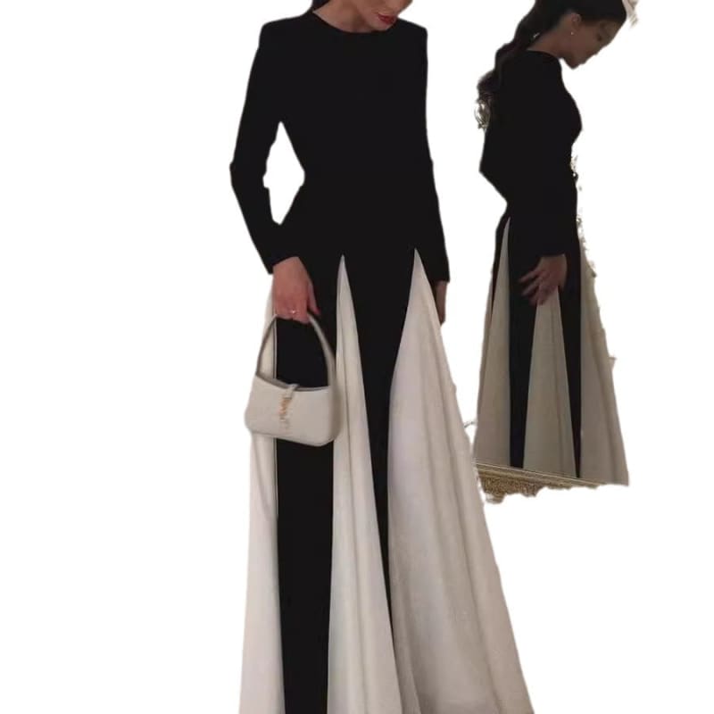 Long-sleeved black and white color-block maxi dress with a high slit and accompanying small handbag.