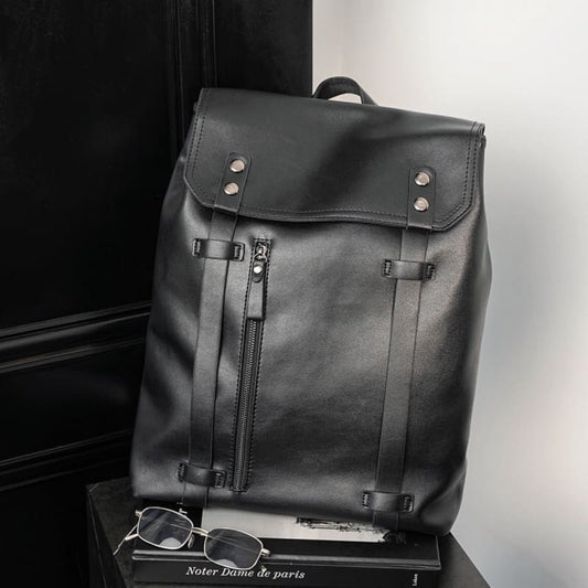 Black leather backpack with metal hardware and a front zipper pocket.