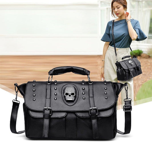 Black leather handbag with a skull emblem and studded details.