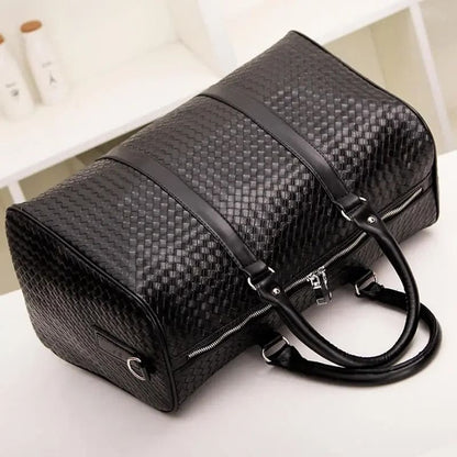 Black leather handbag with a woven texture pattern and dual handles.