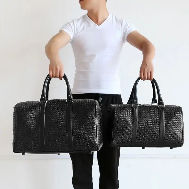 Two black leather woven duffle bags with handles.