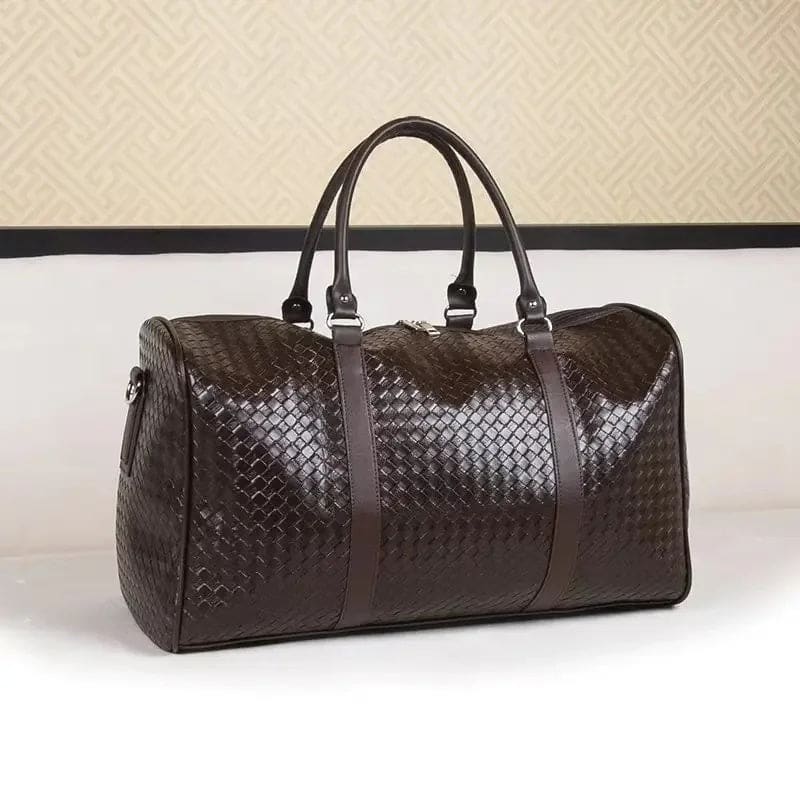 Brown leather woven duffle bag with handles and a shoulder strap.