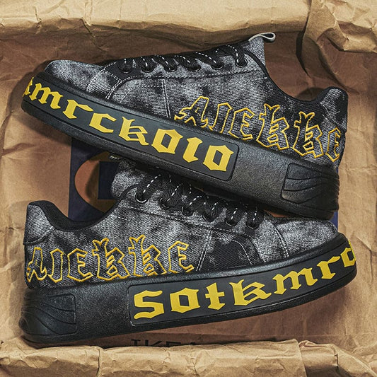 Pair of black and yellow sneakers with ’Anekke’ and ’Sotkmrg’ text on the sides.