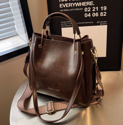 Brown leather handbag with multiple straps and gold-toned hardware.